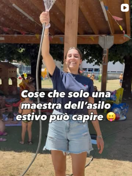 Maestra dell'asilo estivo con tubo acqua